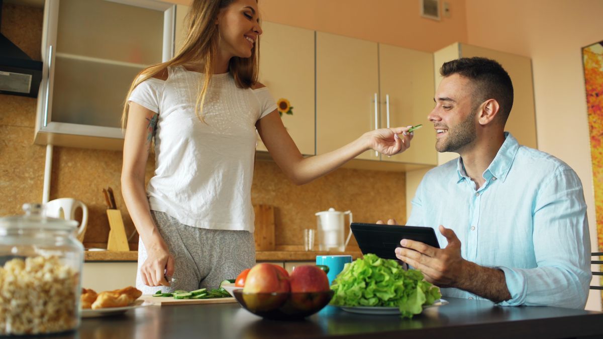 A joyful couple having breakfast together in a cozy kitchen, sharing healthy food.