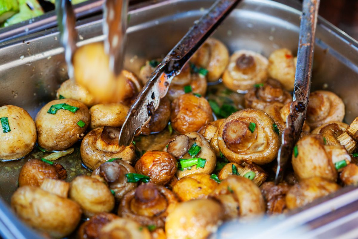 A mouthwatering dish of sauteed mushrooms garnished with green onions. Perfect for food photography enthusiasts.