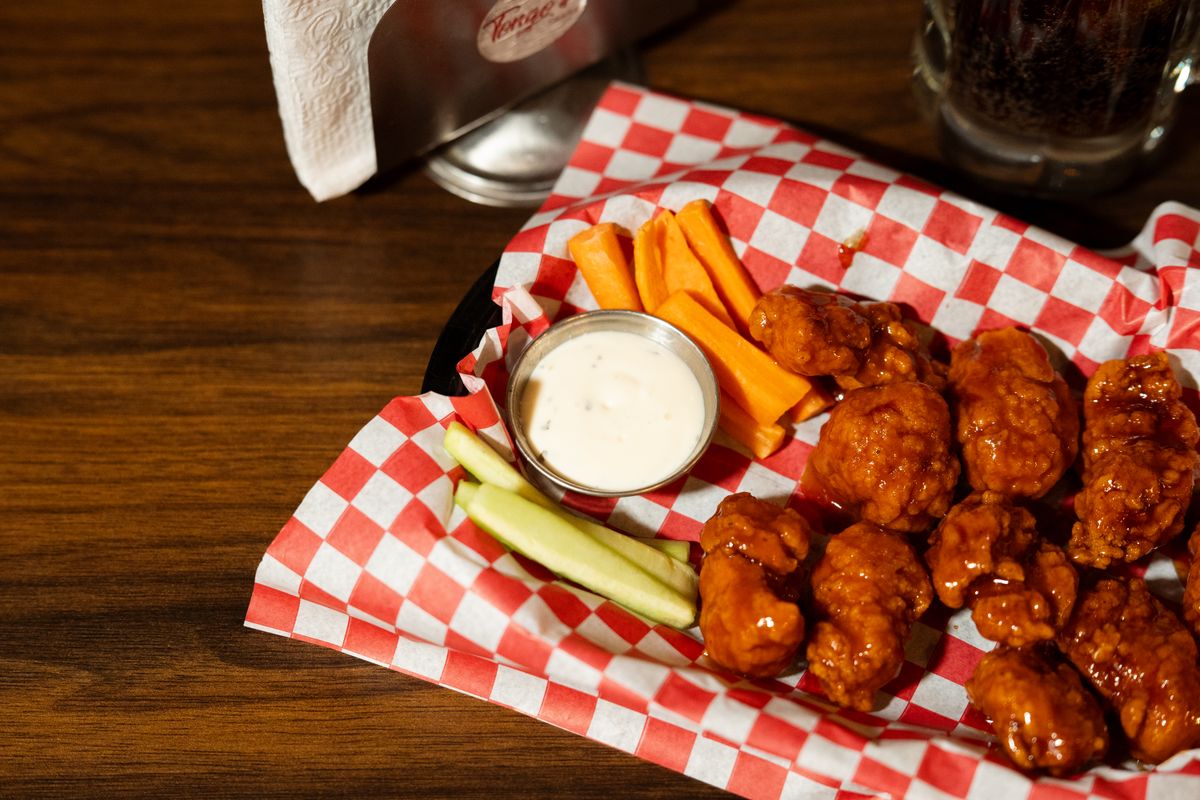 A tempting plate of spicy buffalo wings served with ranch dip, carrots, and celery sticks.