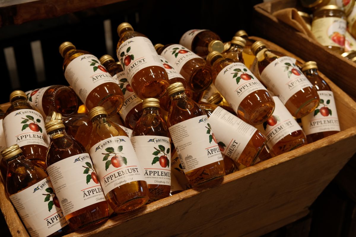 Move Over, Cider Donuts: New England’s Apple Cider Jelly Packs Fall Into a Jar 1 A variety of bottled apple juice arranged in a wooden crate, perfect for market displays.