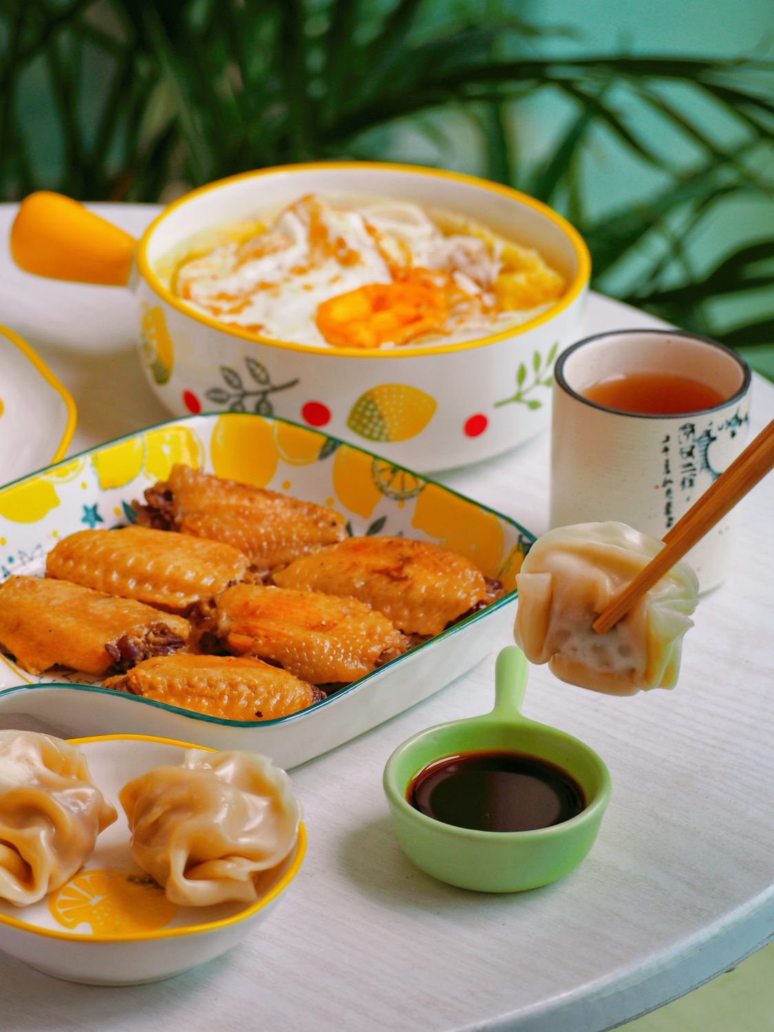 A vibrant Asian food spread featuring dumplings, chicken wings, and a flavorful dish.