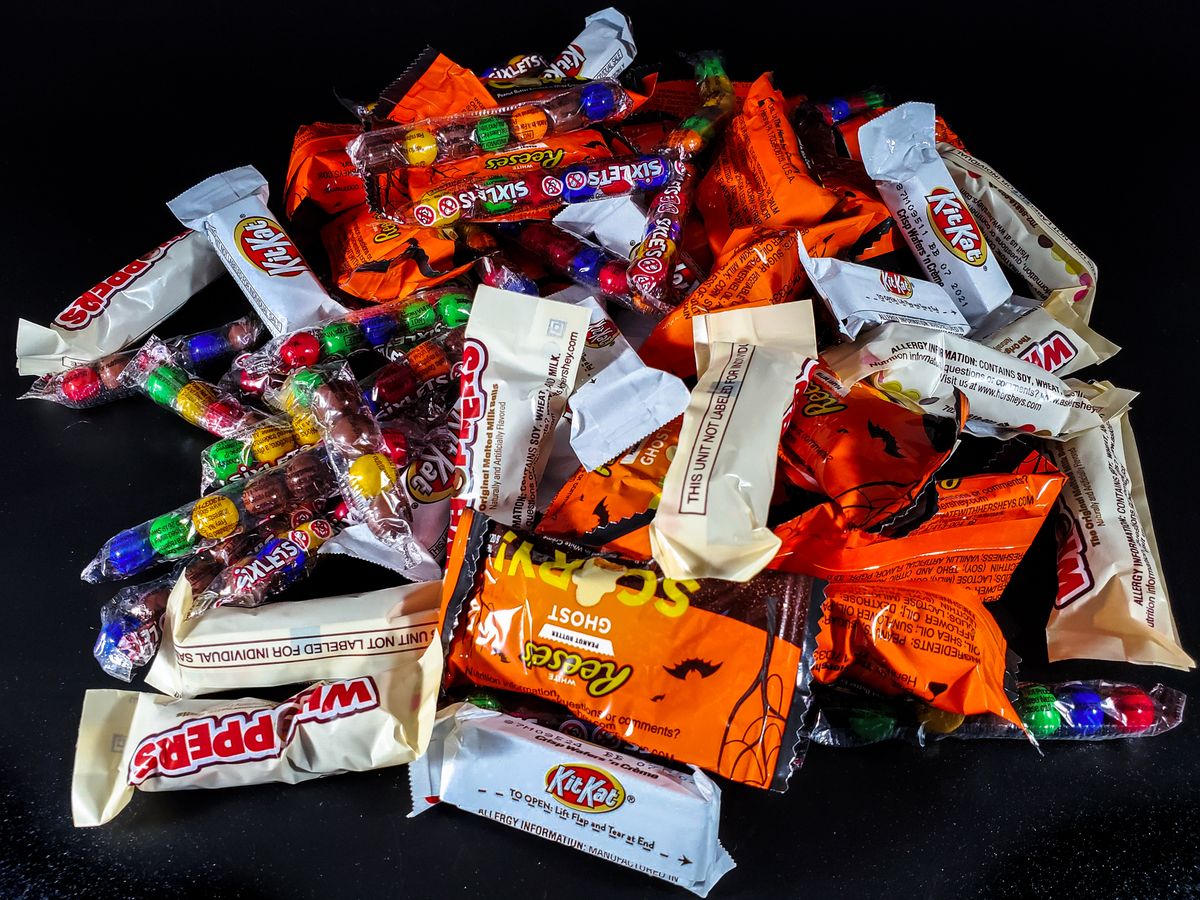 A $29 Bag of Reese’s? Halloween Candy Has Become the Scariest Thing in the Aisle 1 A vibrant pile of assorted Halloween candies, including chocolate bars and sweets, perfect for trick-or-treat fun.