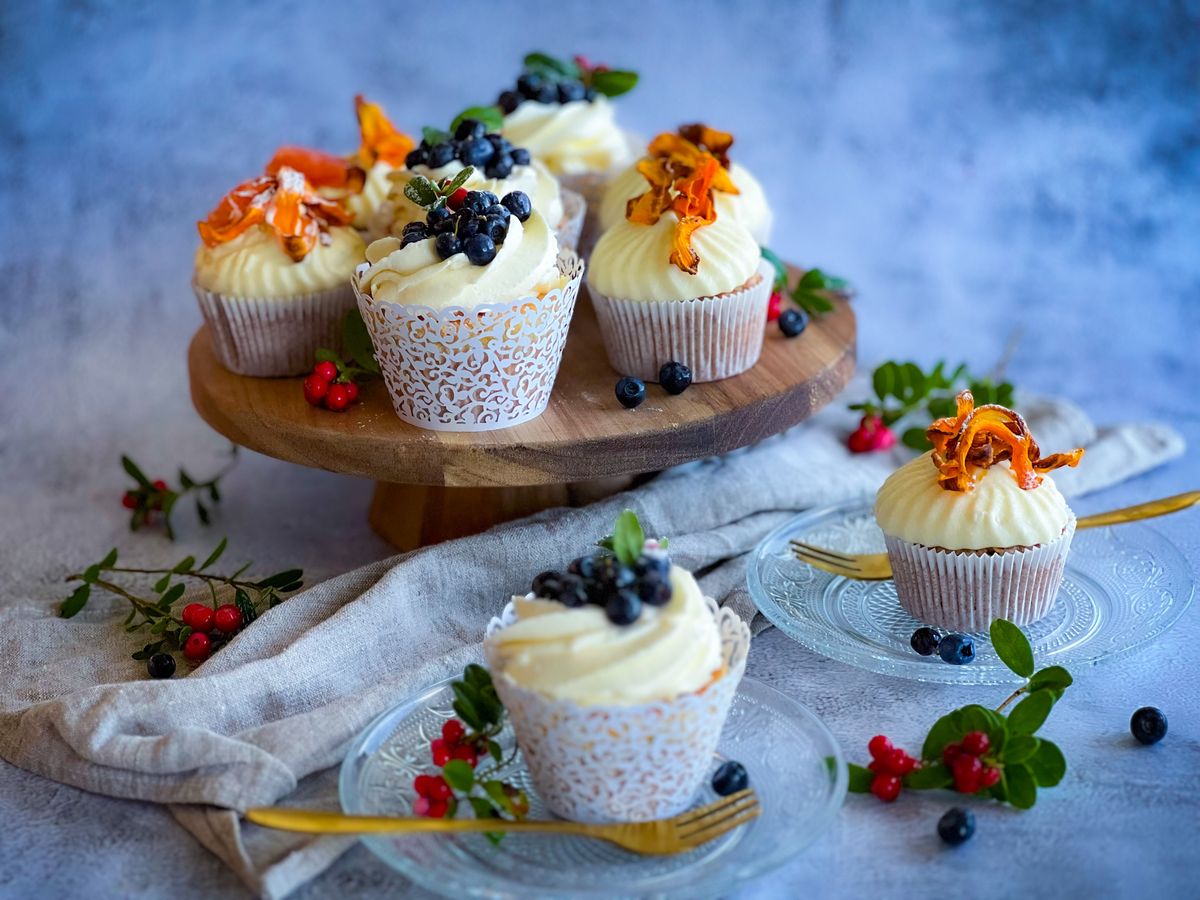 Cranberry-Orange Muffins Bring a Bakery Feel to Your Own Kitchen 2 Aesthetic cupcakes topped with blueberries on a rustic stand, perfect for dessert inspiration.