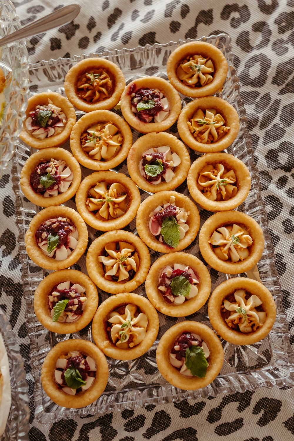 Move Over, Croissants: Savory Tarts Are Giving America’s Bakeries a Delicious Lunch Upgrade 1 An elegant arrangement of mini tarts with various toppings on a glass tray. Perfect for parties and gatherings.