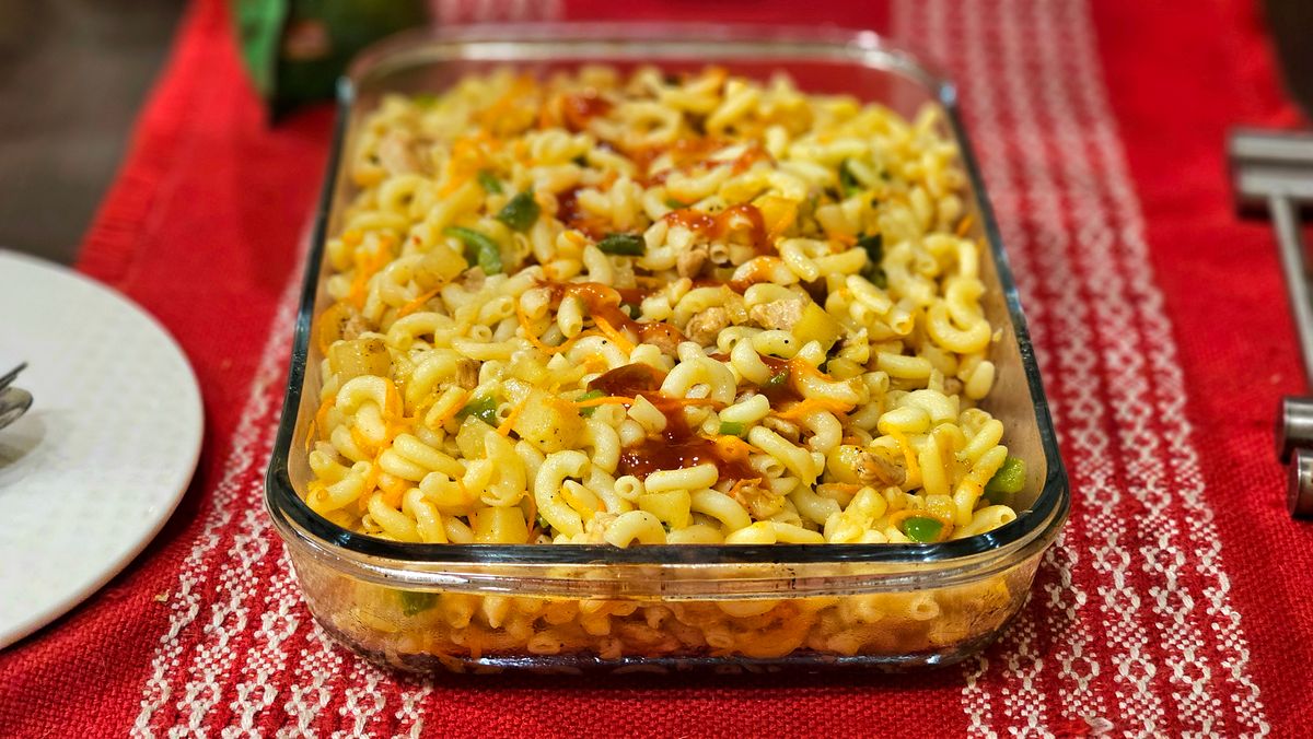 6 Times You Shouldn’t Use Your Glass Baking Dish 1 Appetizing baked macaroni with vegetables in a clear dish on a red tablecloth.
