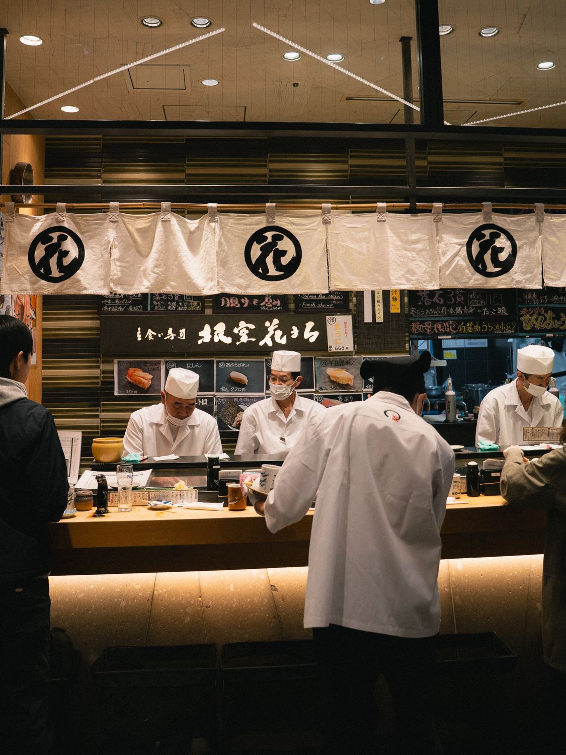 Authentic sushi bar in Japan showcasing chefs preparing fresh sushi delicacies. Inviting ambiance with a touch of cultural essence.