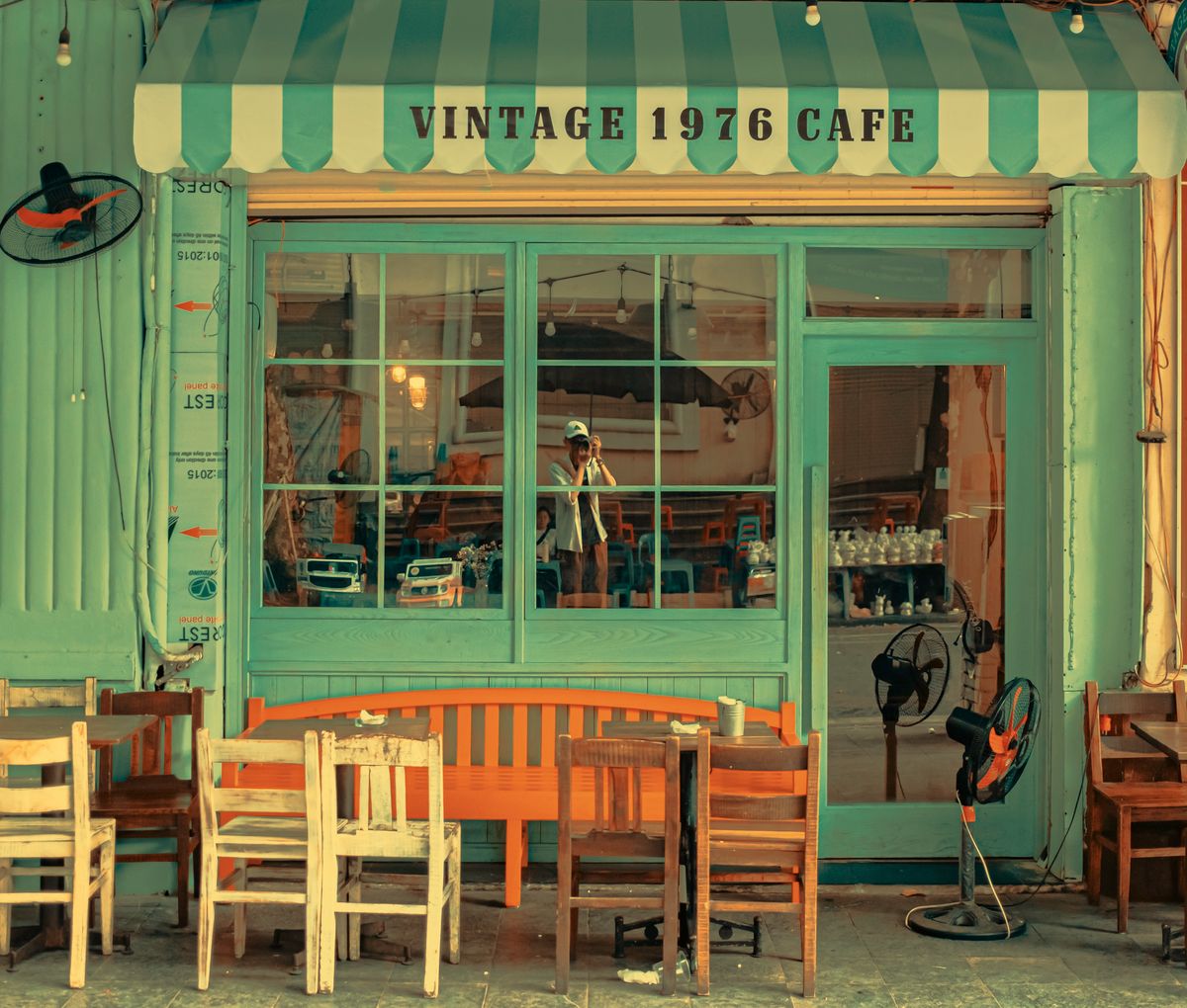 Charming vintage café facade featuring retro chairs and tables in a cozy outdoor setting.