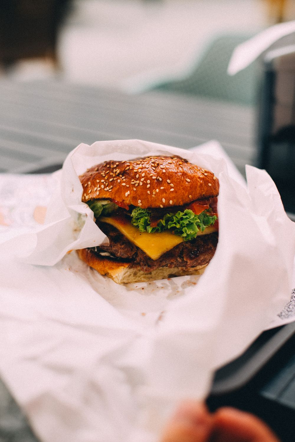 Close-up of a freshly made cheeseburger with lettuce and cheese.