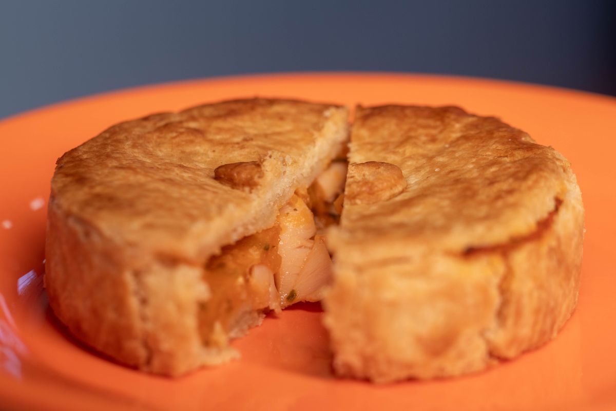 Close-up of a savory chicken pot pie with a slice cut out, showing filling.