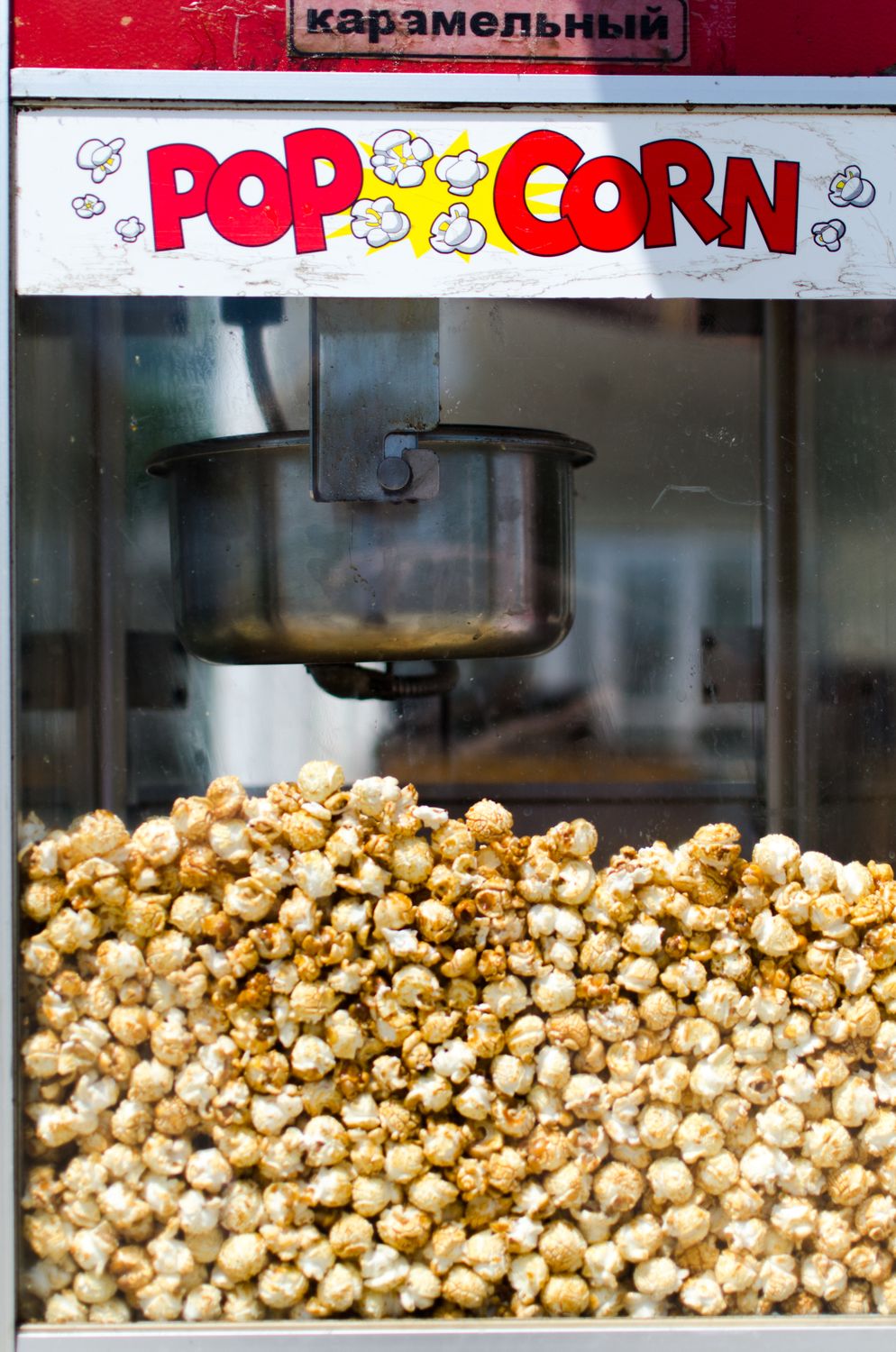 Close-up of delicious caramel popcorn in a retro-style popcorn machine, perfect for snacks and movie nights.