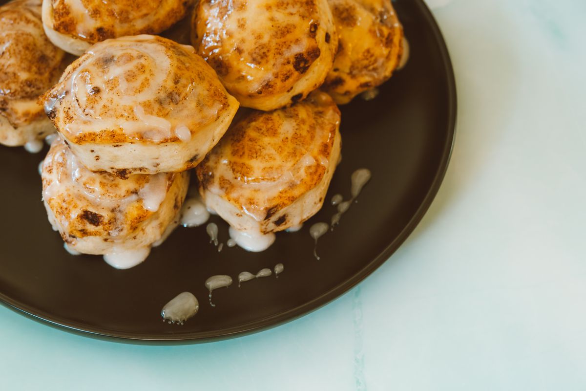 6 Mall Treats That Were Part of Shopping Trips in the ’90s 1 Close-up of freshly baked cinnamon rolls with icing, perfect for dessert or breakfast.