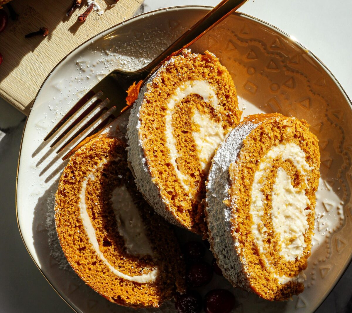 Close-up of pumpkin Swiss roll cake with cream and spices, perfect for fall desserts.