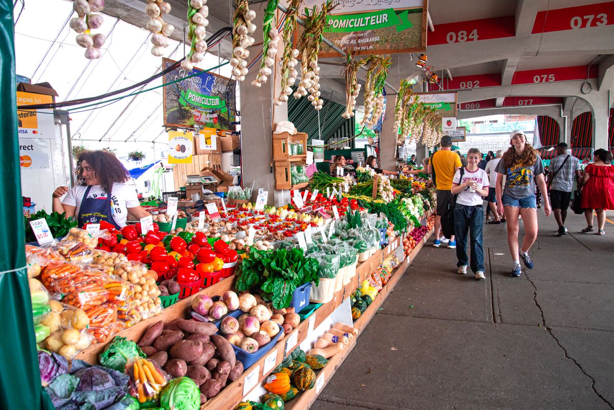 Detroit’s Eastern Market Has Kept People Coming Back Since 1891, and It’s Not Just the Produce 2 Colorful farmers market scene with a variety of fresh vegetables and shoppers exploring the stalls.