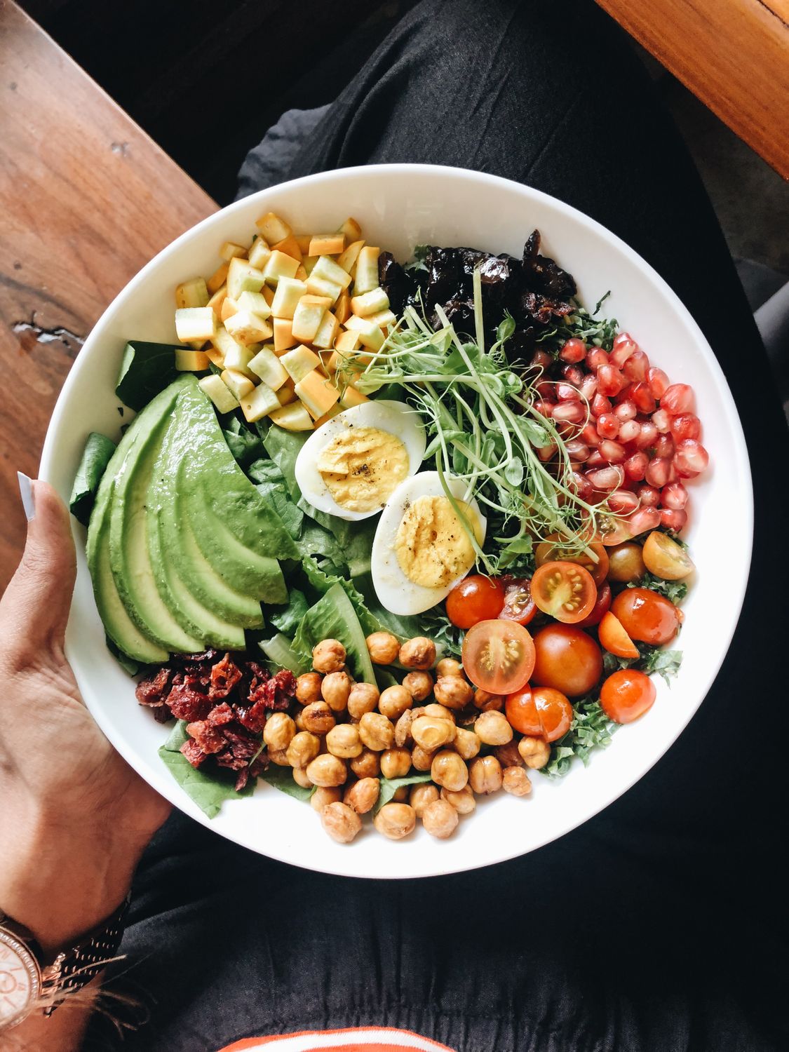 Colorful salad bowl with avocado, eggs, tomatoes, and more, perfect for a healthy meal.
