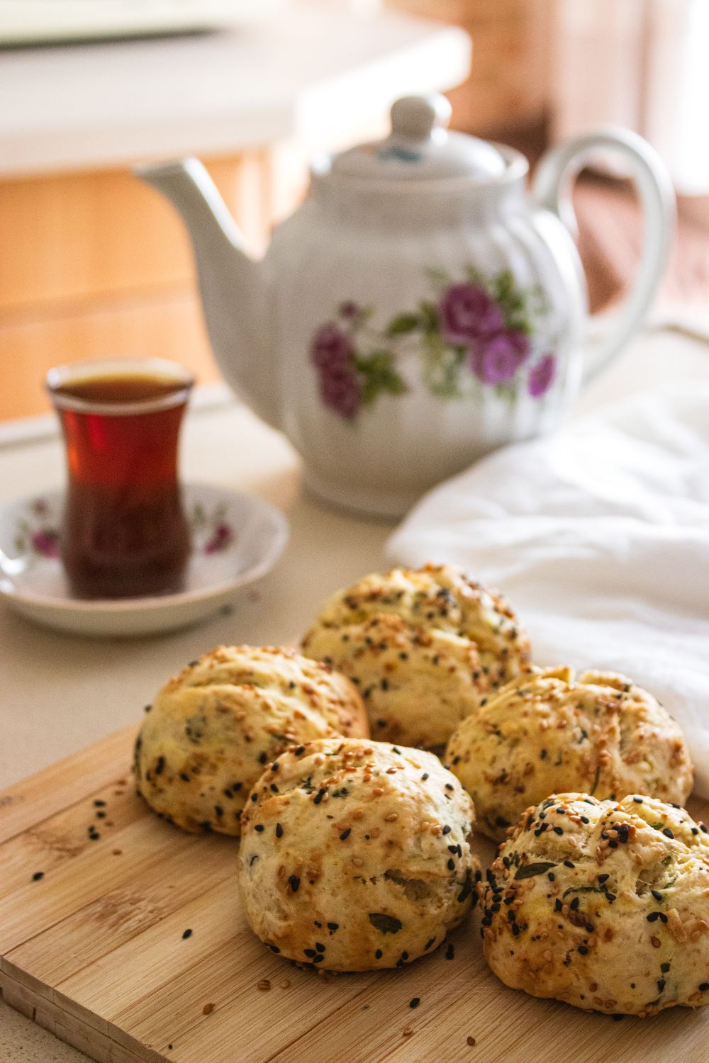 Cozy tea setup with freshly baked savory muffins and floral teapot.