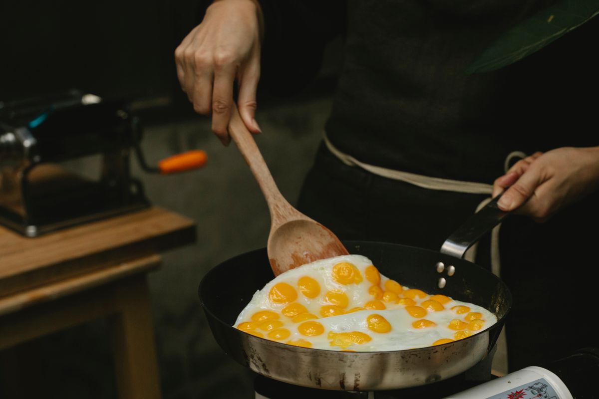 6 Kitchen Items You Should Replace Sooner Than You Think 2 Crop anonymous chef with wooden spatula frying fresh organic quail eggs on pan in modern kitchen