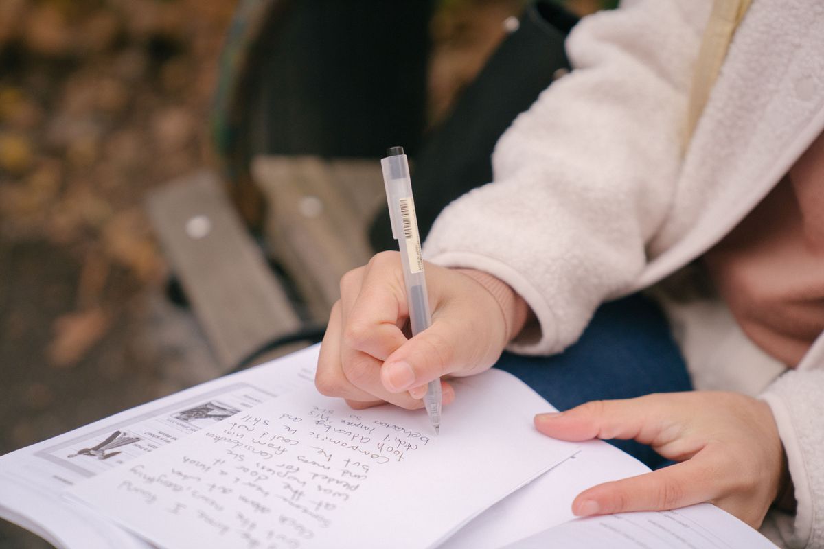 Los Angeles Grocery Store is Turning Into a Stage for Egg Stories Tonight 1 Crop unrecognizable woman in casual outfit sitting on wooden bench while taking notes on paper near textbook in street with foliage on ground in daylight in autumn