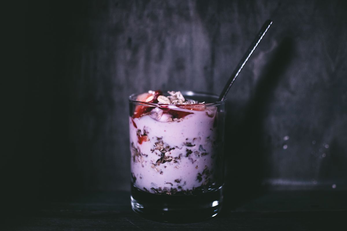 9 Foods Marketed as Healthy That May Be Misleading 1 Dark, moody close-up of a delicious yogurt parfait with granola and berries in a glass.