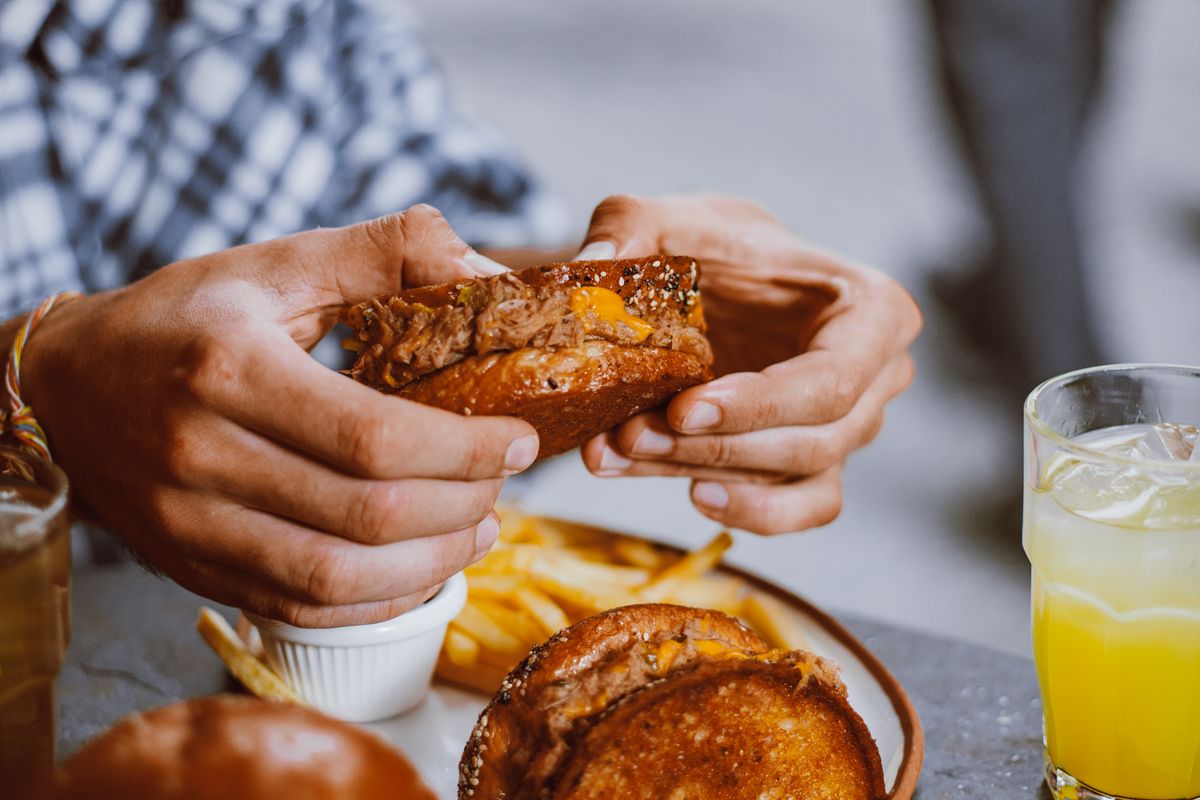 Delicious beef sandwich with fries and drinks, perfect for a casual meal.