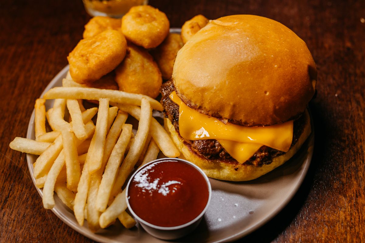 6 All-Time Favorite American Recipes That Never Go Out of Style 1 Delicious cheeseburger with fries, nuggets, and ketchup on a plate.
