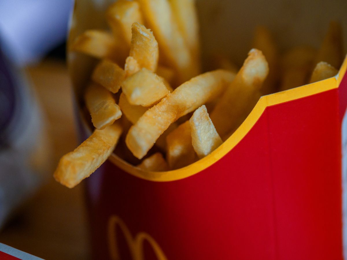 Delicious golden french fries in a red box, perfect fast food snack.