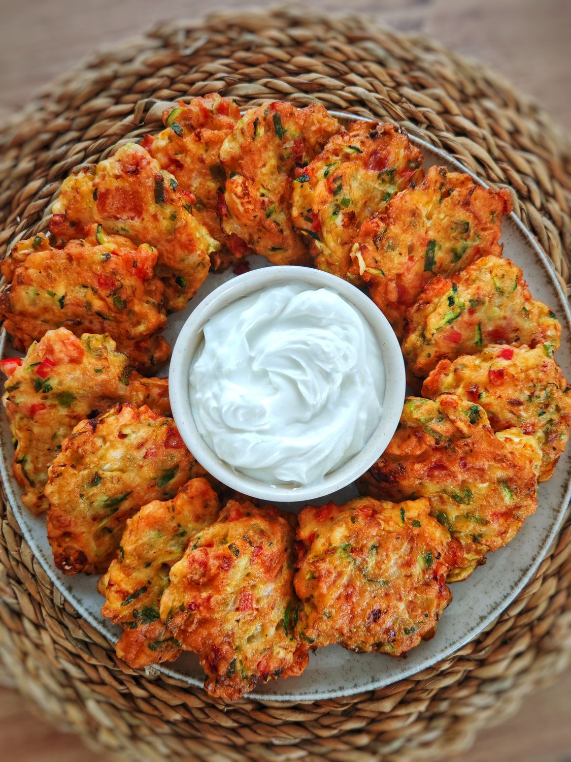 Delicious golden vegetable fritters served with a creamy dipping sauce, perfect for appetizers.
