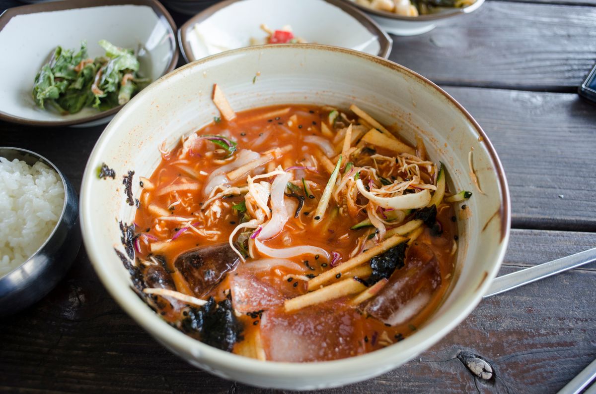 Delicious Korean noodle soup with spicy broth, vegetables, and seaweed.