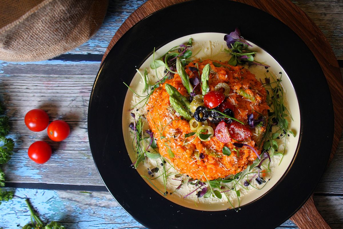 Delicious vegetable risotto presented beautifully with fresh garnishes on a rustic wooden table.