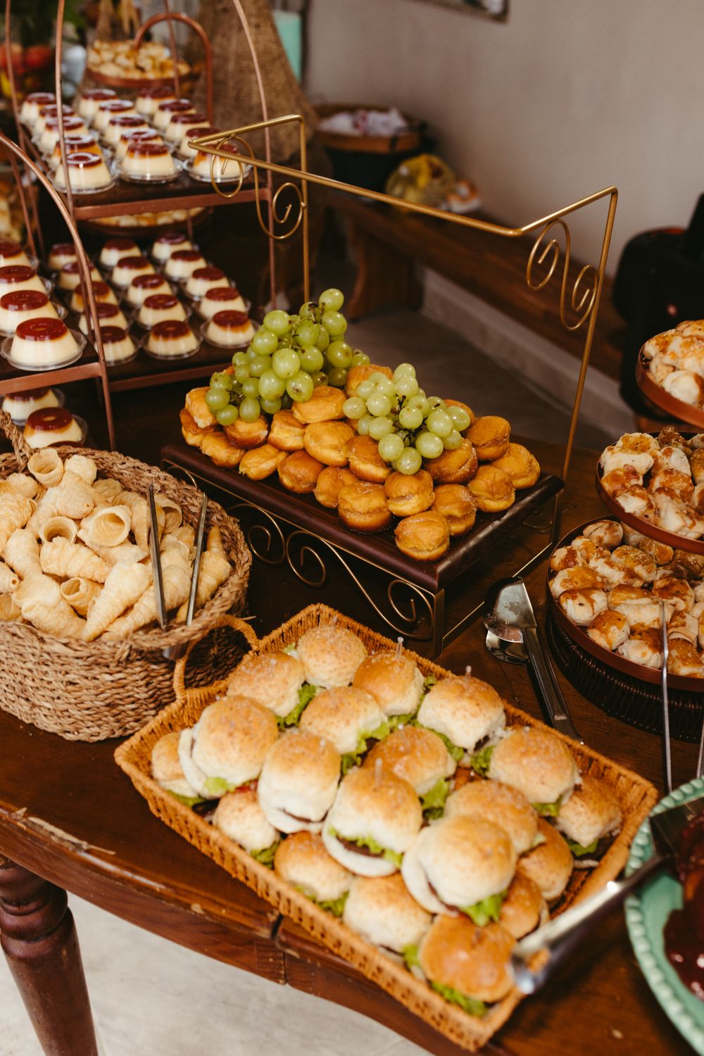 Elegant buffet setup with a variety of pastries, grapes, and mini sandwiches, perfect for events.