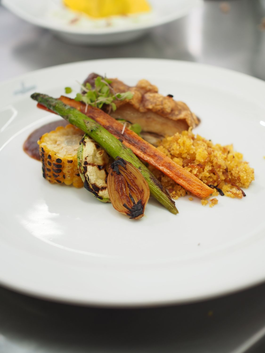 Elegant gourmet dish featuring roasted vegetables and poultry, perfect for fine dining settings.