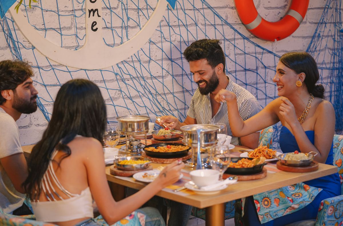 Kansas City’s Newest Restaurant Openings: 8 Places to Try This Fall 1 Four adults enjoying a meal together at a lively restaurant setting, showcasing happiness and togetherness.