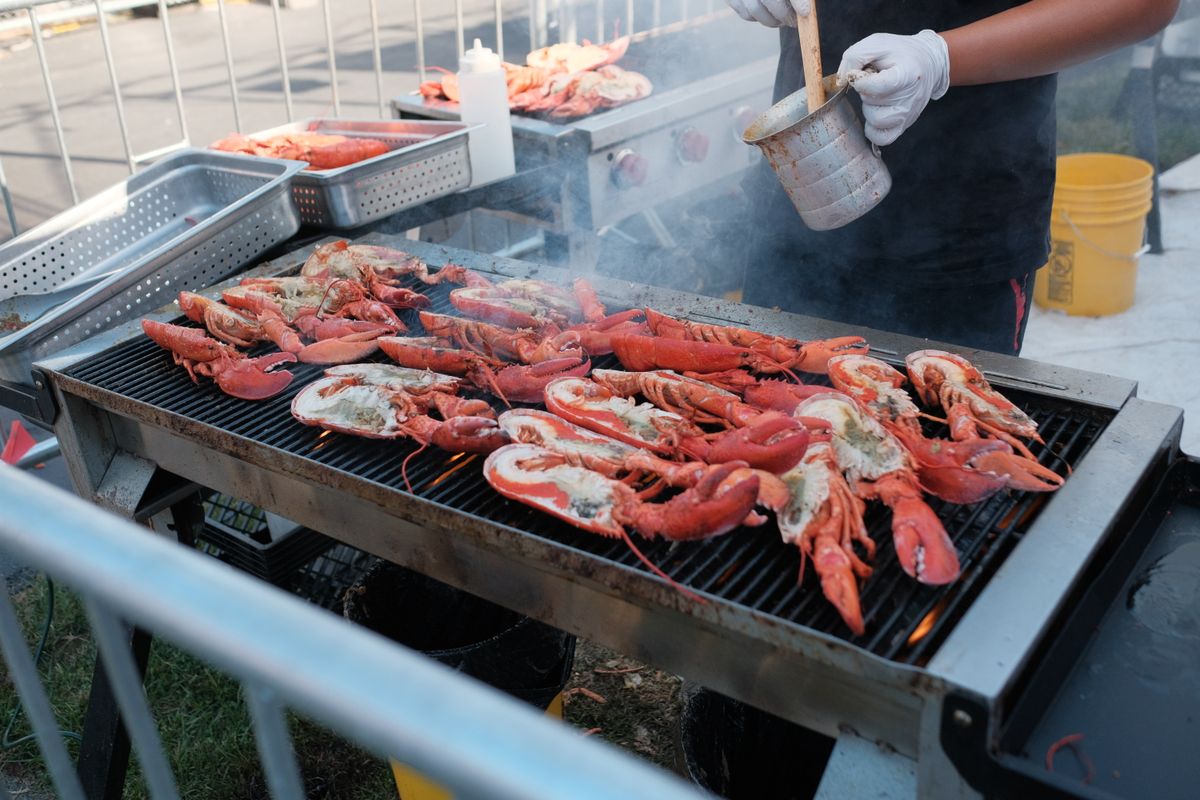 7 Foods Once Considered Poor Man’s Meals That Rich People Love Today 1 Fresh lobsters being grilled outdoors on a barbecue with seasoning for a flavorful meal.