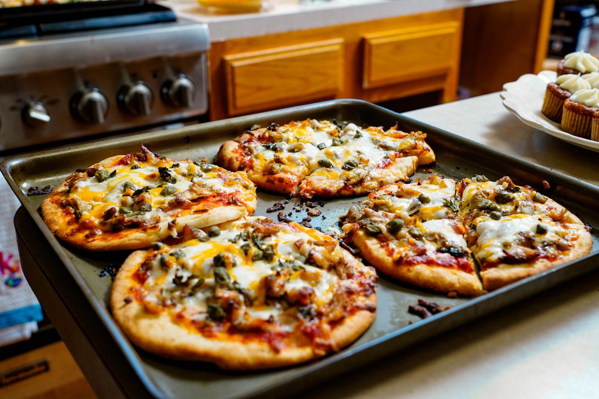 9 Leftovers That Turn Rubbery or Soggy in the Microwave 1 Freshly baked pizzas with melted cheese on a kitchen counter, ideal for foodies.