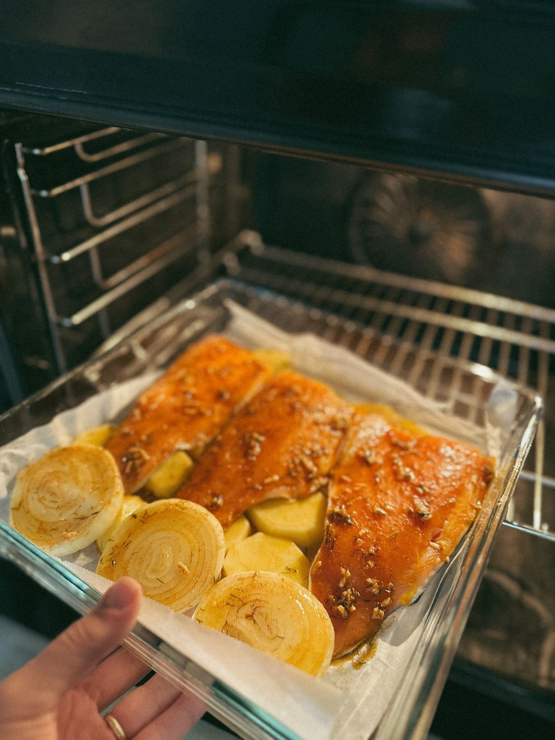 The Foil-Packet Salmon Dinner That Keeps Cleanup to a Minimum 1 Freshly baked salmon with onions and potatoes in the oven, ready to serve.