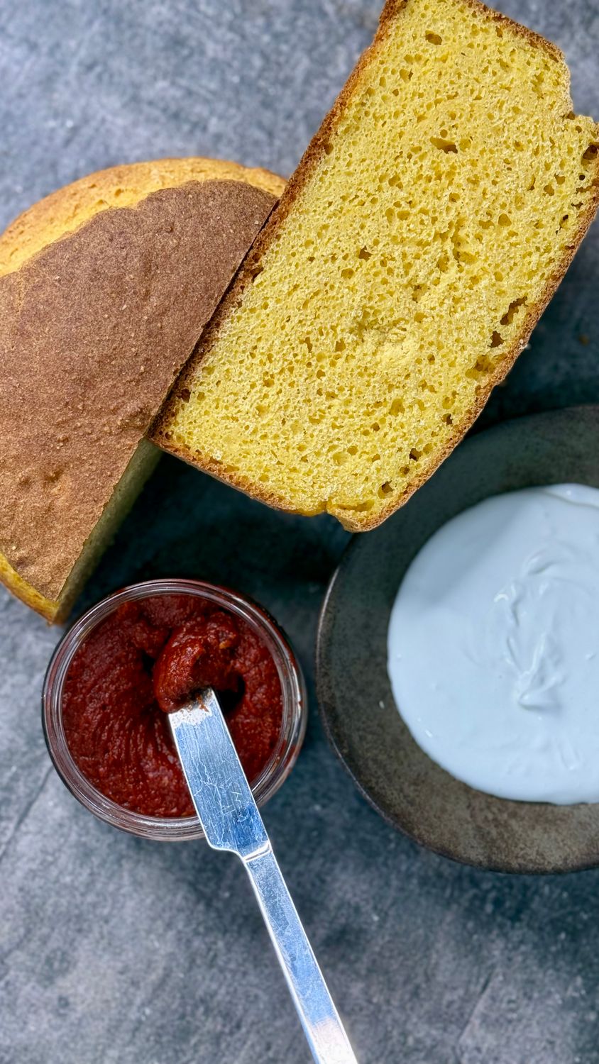 Golden cornbread served with creamy yogurt and spicy salsa for a delightful snack.