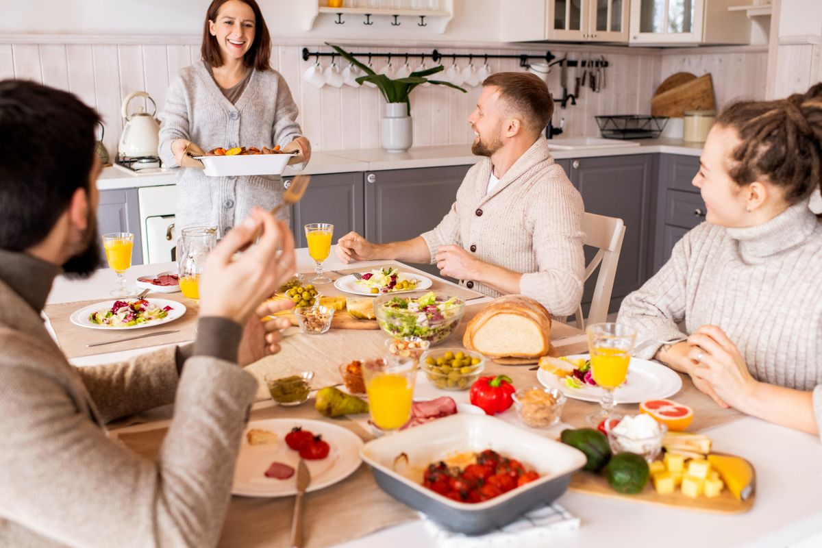 8 Little Changes That Could Make a Big Difference in Your Grocery Bill 1 Group of friends enjoying a vibrant meal indoors, sharing laughter and good food.