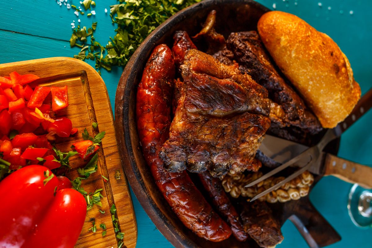 Before Chicken Ruled Dinner, Americans Ate These 8 Meats, Some Might Surprise You 2 Mouthwatering platter with grilled meats, sausages, and fresh vegetables on a wooden board.