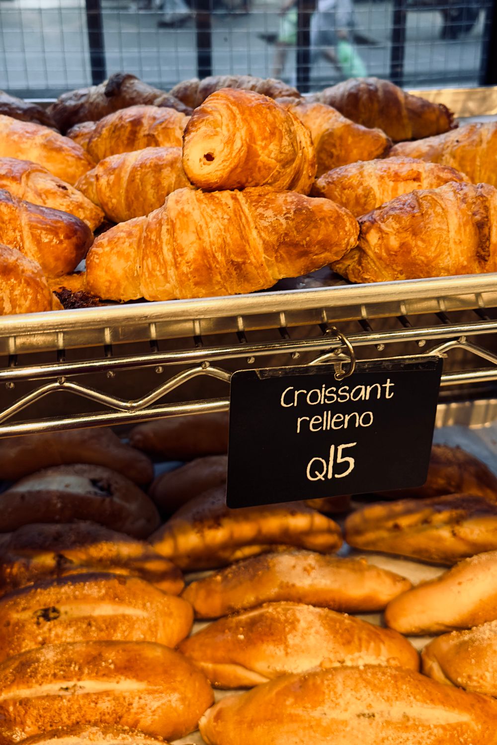 Plenty of croissants and bread on shelves, outdoor bakery, Guatemala City.
