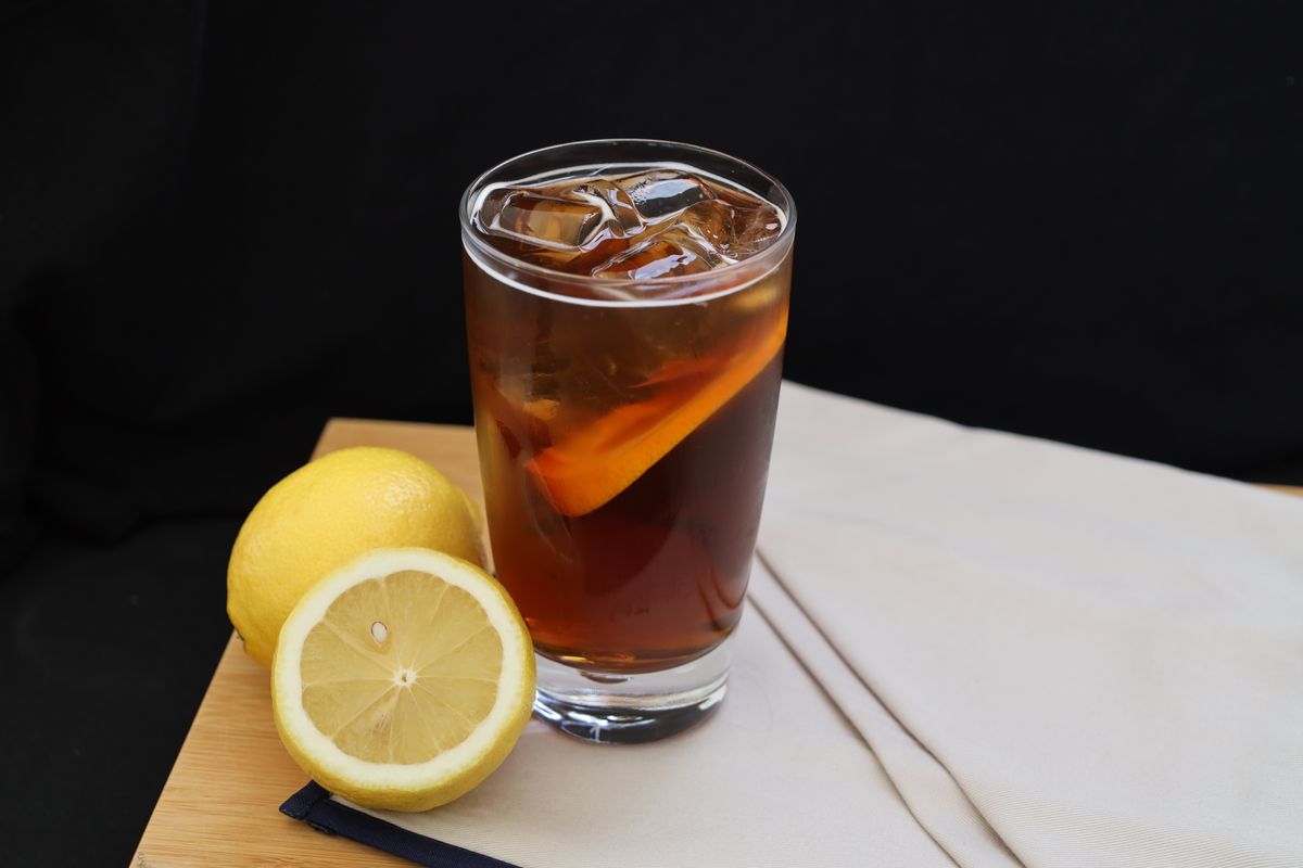 Refreshing iced tea with ice cubes and lemon slices, perfect for a hot day.