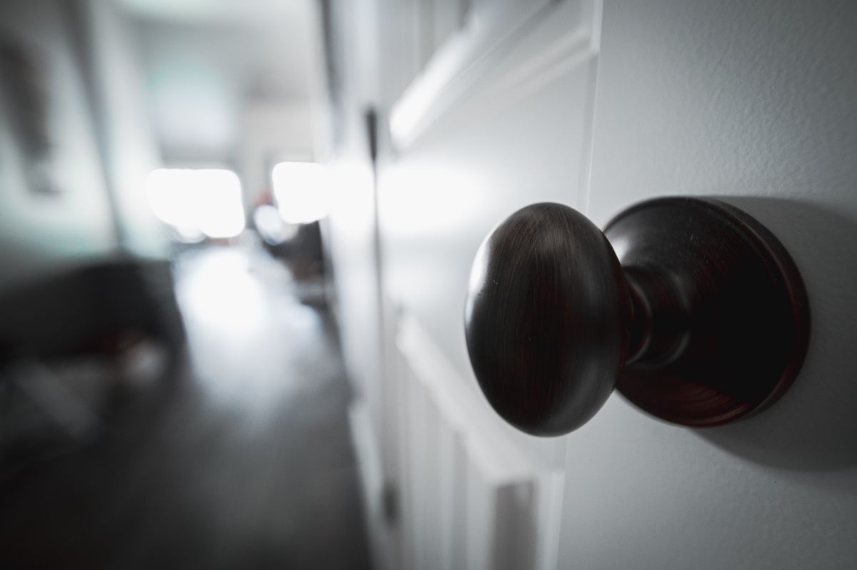 7 Things You Should Think About Cleaning With Lysol Spray 1 Round metal knob with glare from the light on white wooden door in apartment
