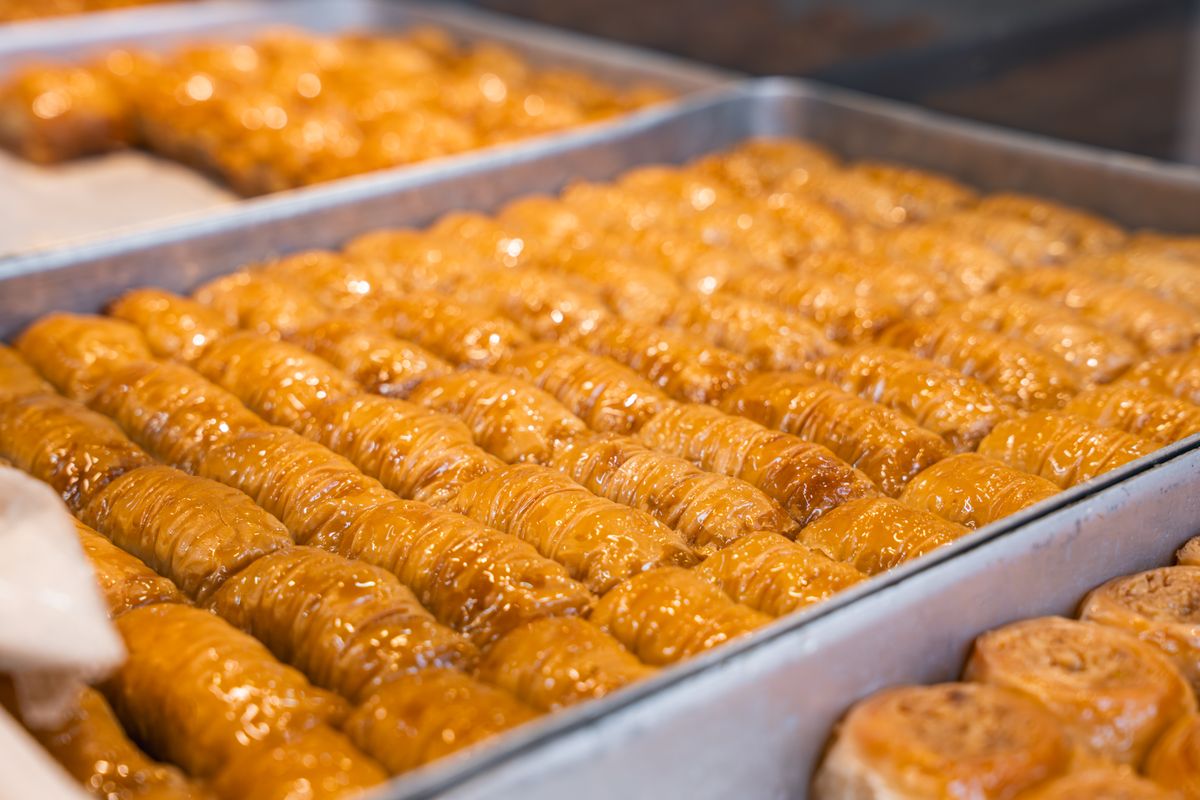 Rows of golden baklava in trays, showcasing fresh bakery goods.