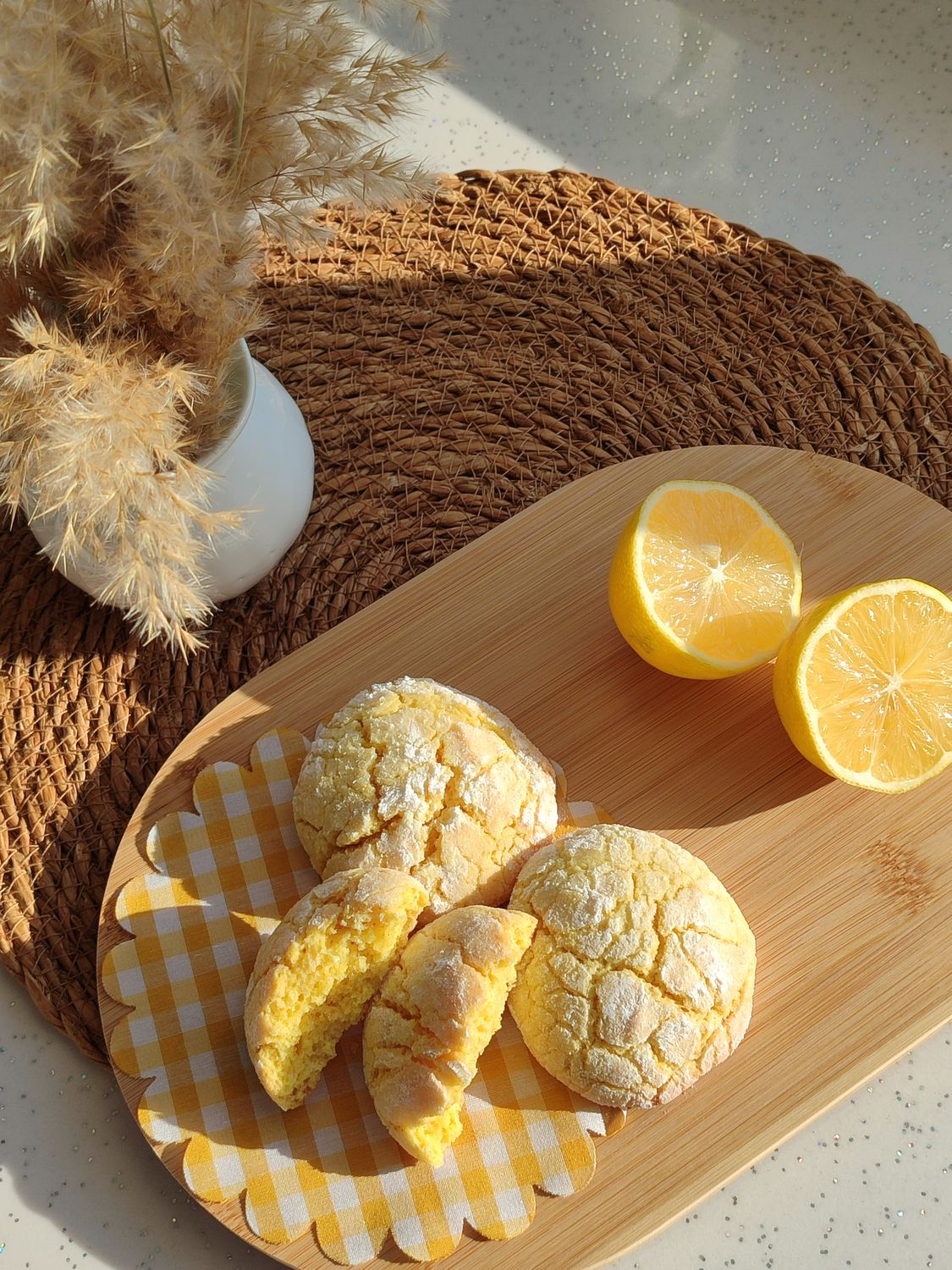 Sunlit lemon cookies paired with fresh slices on a rustic wooden board.