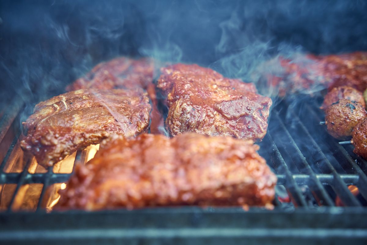 Tasty barbecue ribs sizzling on the grill, perfect for summer gatherings.
