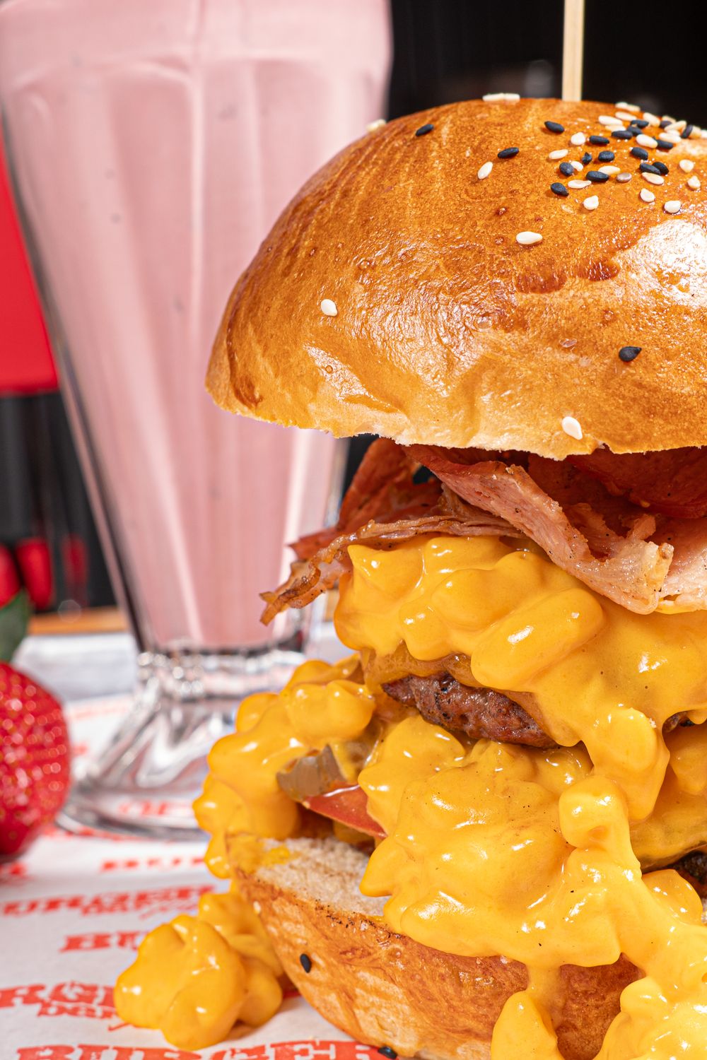 Tasty cheeseburger with bacon and a pink milkshake, perfect for a foodie's delight.
