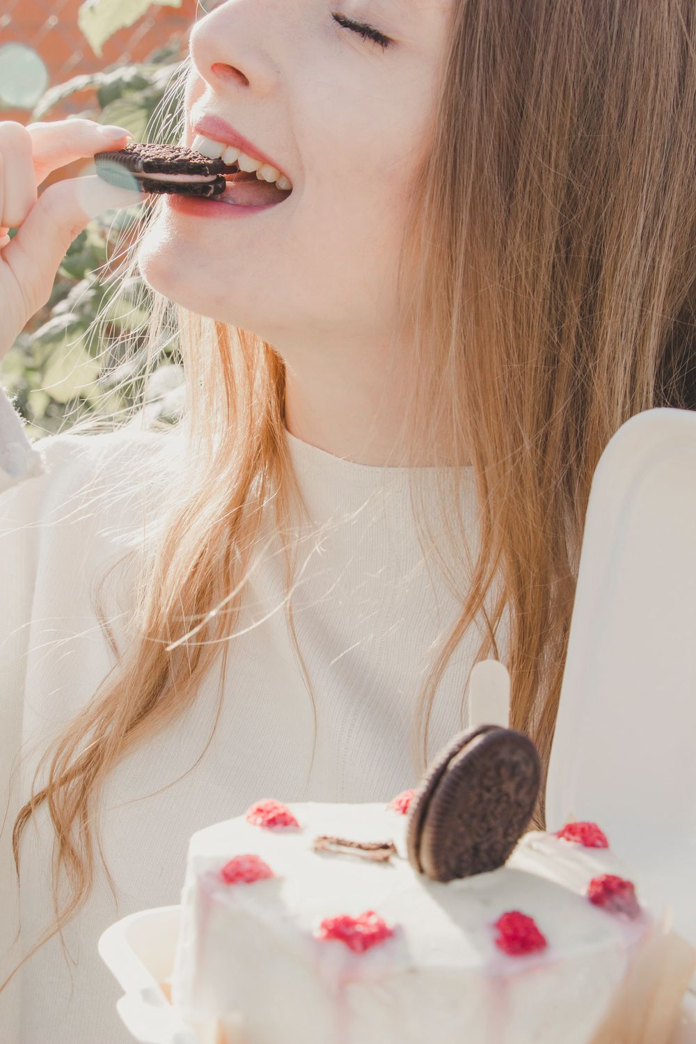These Chocolate-Kissed Florentines Look Straight From a Bakery, and They Start in a Saucepan 1 Woman savoring a cream cake with chocolate biscuits outdoors.
